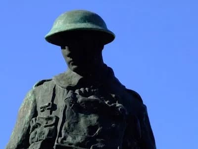 Monumento solene em homenagem ao soldado português com flores depositadas e uma chama eterna em sinal de respeito.