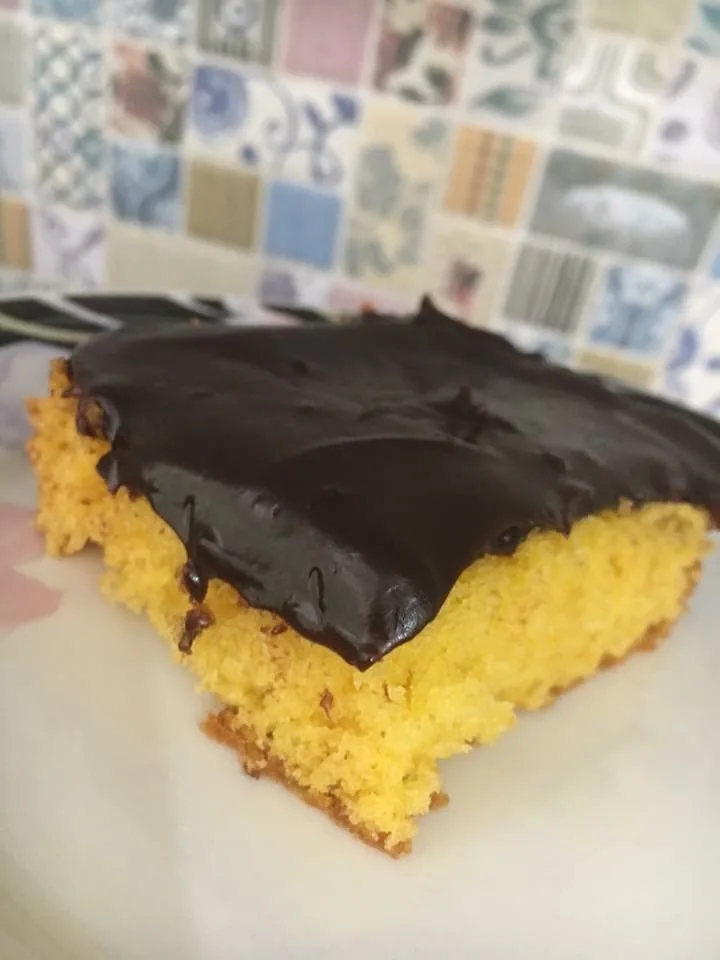 Bolo de cenoura fofinho coberto com ganache de chocolate brilhante em um prato