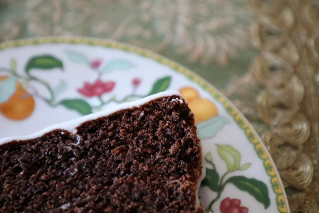 Um apetitoso bolo de chocolate caseiro com cobertura de glacê branca, acabado de sair do forno.