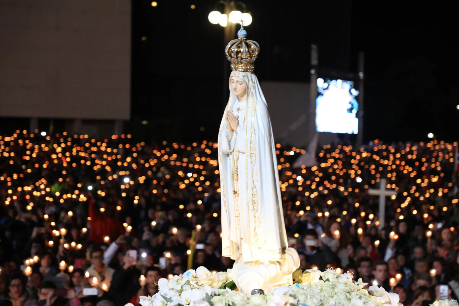 Fiéis reunidos em oração e procissão no Santuário de Fátima durante a peregrinação anual.