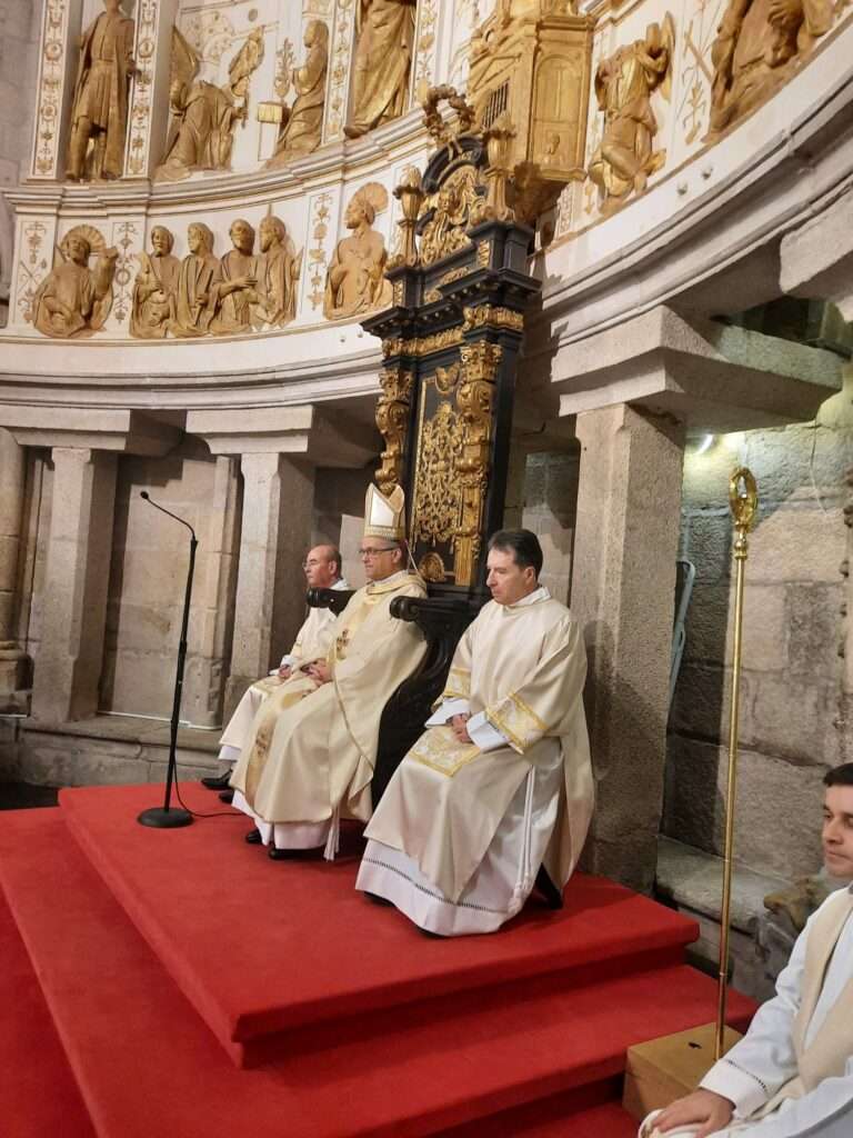 O Bispo D. José Pereira com a mitra, sentado na cátedra ladeado por dois sacerdotes, durante a Missa Crismal. O báculo pastoral está visível.
